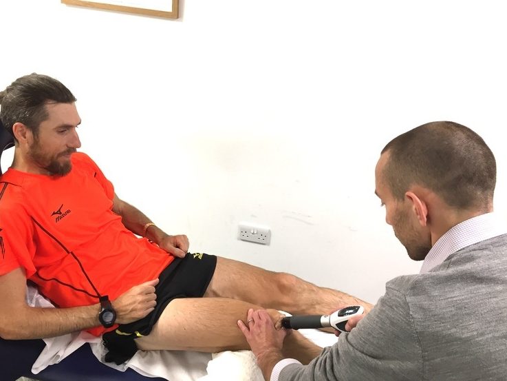 Physiotherapist Scott Newton giving shockwave therapy to Paul Martelletti