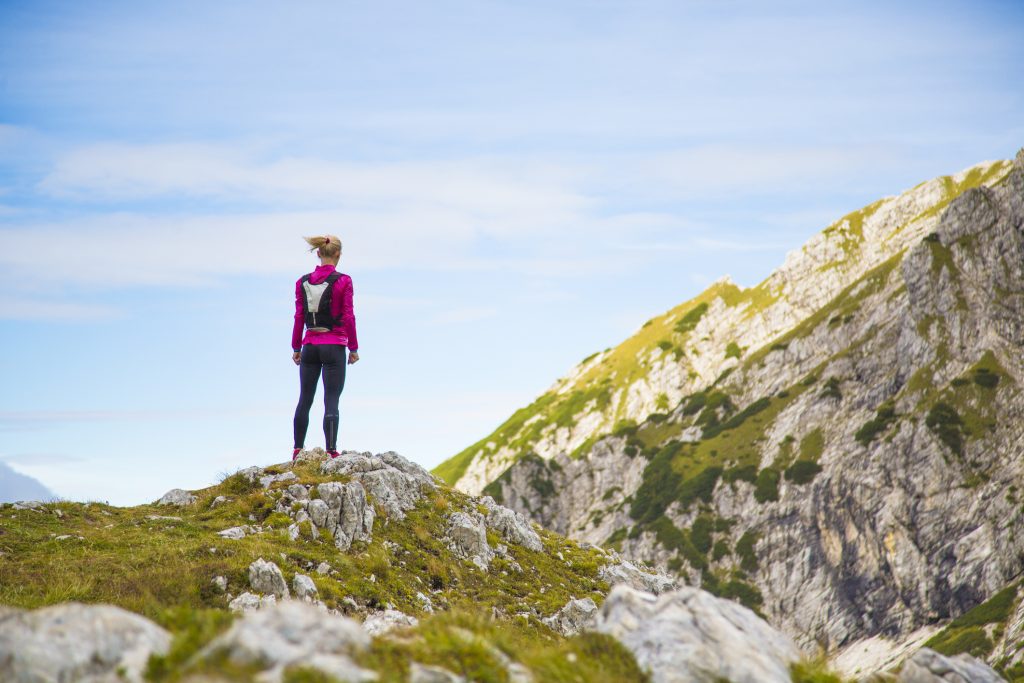 Female trail runner standing in mountains